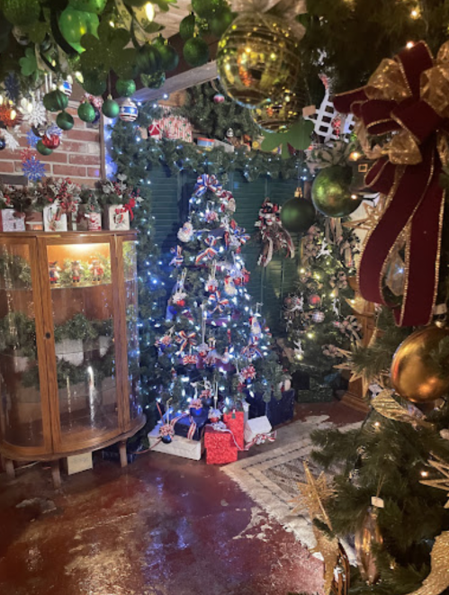 A cozy room decorated for Christmas, featuring a lit tree, ornaments, and festive decorations throughout.