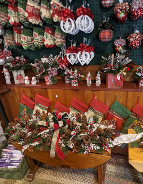 A festive display of Christmas decorations, including stockings, ornaments, and a floral arrangement with pinecones.