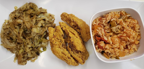 A plate with fried fish, sautéed cabbage, and a serving of seasoned rice with vegetables.