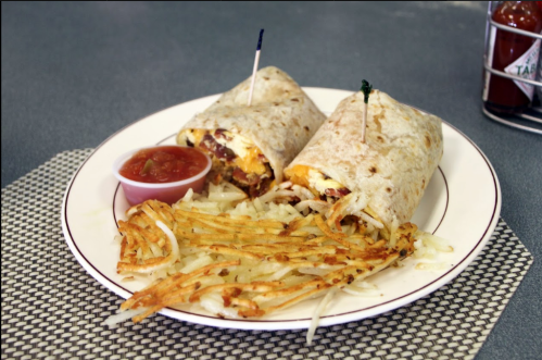 A plate with two burritos, a side of crispy hash browns, and a small cup of salsa.