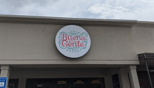 Sign for "Buena Gente Bakery," featuring a colorful logo with a Cuban theme on a storefront.