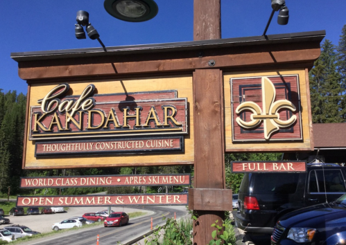 Sign for Cafe Kandahar featuring "Thoughtfully Constructed Cuisine," with details about dining and seasonal availability.