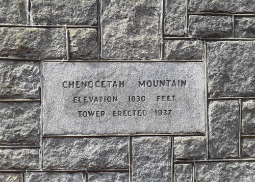 Stone plaque on a wall, reading "Chenocetah Mountain, Elevation 1830 Feet, Tower Erected 1937."