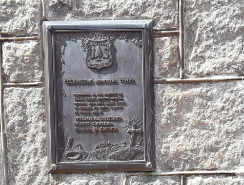 Plaque on a stone wall commemorating the Checotah Memorial Tower and honoring individuals involved in its creation.