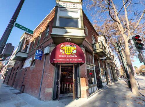 Exterior of Teske's Germania restaurant and beer garden, featuring a red awning and corner street sign.
