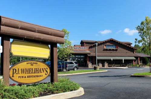 A rustic pub and restaurant building with a sign reading "P.J. Whelihan's" and a clear blue sky in the background.