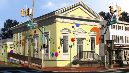 A colorful building with a yellow exterior and playful polka dots, located at the intersection of Main and Rank Streets.