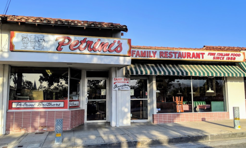 Exterior of Petrini's Family Restaurant, featuring a sign and a carry-out window, with a sunny day backdrop.