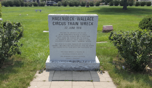 A stone monument commemorating the Hagenbeck-Wallace Circus train wreck on June 22, 1918, in a grassy area.