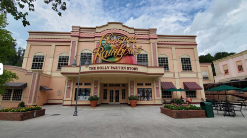 Exterior of the "Chasing Rainbows: The Dolly Parton Story" building, featuring a colorful facade and outdoor seating.
