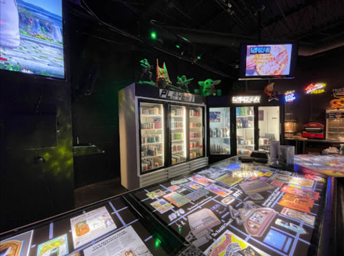 A vibrant arcade interior featuring gaming consoles, neon signs, and a large interactive table with game graphics.