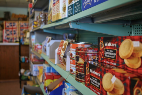 A grocery store shelf filled with various packaged foods, including cookies and snacks, in a cozy setting.
