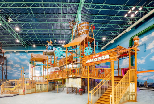 Colorful indoor playground structure with slides, climbing areas, and themed decorations resembling a port.