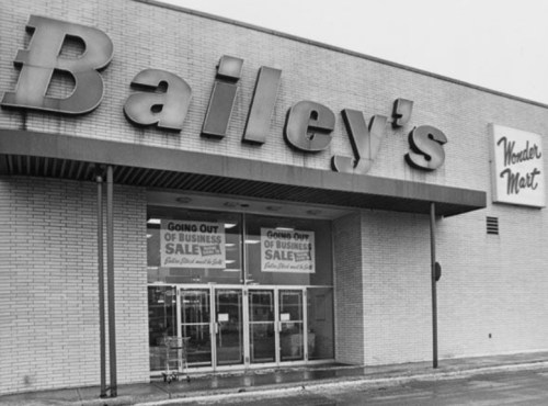Black and white image of a storefront with "Bailey's" and "Wonder Mart" signs, featuring a "Going Out of Business Sale" banner.