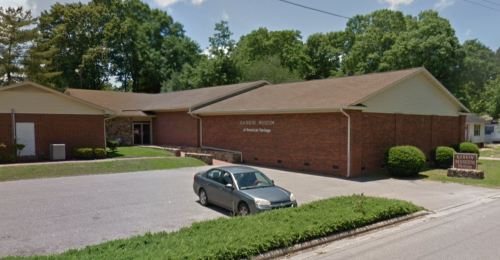 Exterior view of the Banner Museum, a brick building surrounded by trees and a parking area.