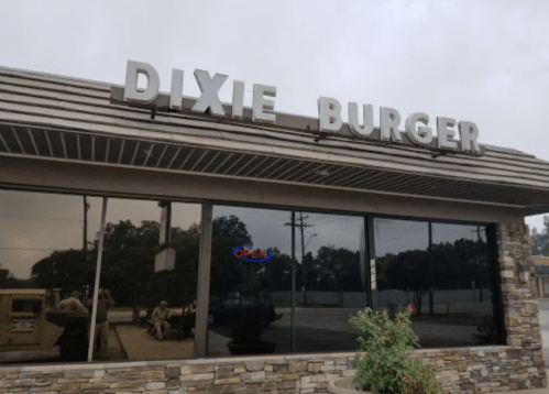 Sign for "Dixie Burger" on a restaurant exterior with an "OPEN" neon sign visible in the window.