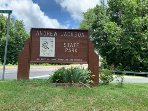 Sign for Andrew Jackson State Park in South Carolina, surrounded by greenery and blue skies.