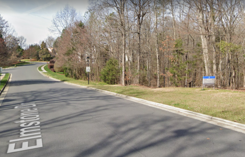A quiet road named Elmstone Drive, lined with trees and a sign indicating a speed limit.