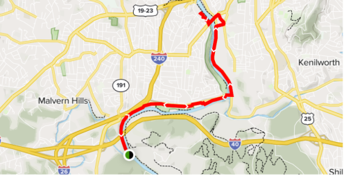 Map showing a route with red lines indicating traffic or detours, surrounded by streets and landmarks in a city.