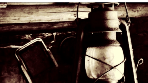 A vintage lantern hangs against a rustic background, evoking a nostalgic, old-fashioned atmosphere.