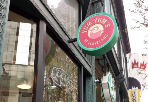 Sign for "Yum Yum's of Cleveland" hangs above a storefront with an "OPEN" neon sign visible in the window.