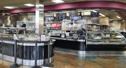 A modern restaurant interior featuring a service counter, display cases, and menu boards.
