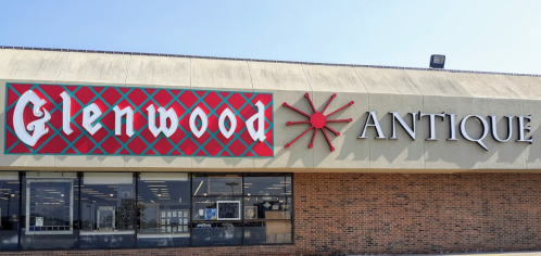 Exterior of Glenwood Antique store, featuring a colorful sign and large windows under a clear blue sky.
