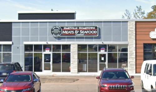 Exterior of Hartville Hometown Meats & Seafood Company, featuring a modern storefront with large windows and a sign.