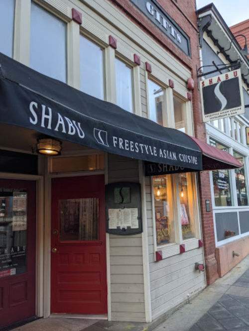 Exterior of a restaurant named "Shabu" with a black awning and a sign, showcasing a cozy, inviting atmosphere.