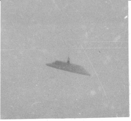 A blurry, black-and-white image of an unidentified flying object (UFO) in the sky.