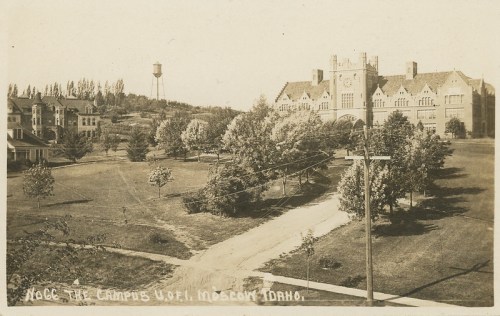 Historic view of the University of Idaho campus in Moscow, featuring buildings and trees, with a water tower in the background.
