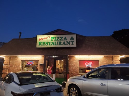 Exterior of Mario's Pizza & Restaurant at dusk, with an "Open" sign and parked cars in front.