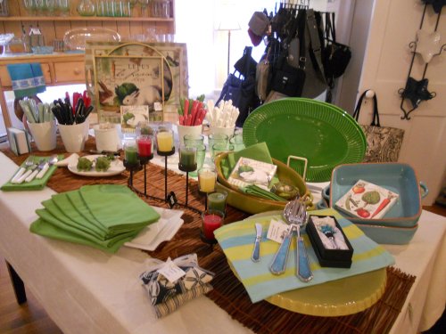 A table set with green tableware, utensils, candles, and decorative items, creating a vibrant dining display.