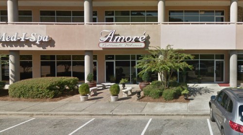 Exterior view of Amore Italian Restaurant, featuring a sign and outdoor seating area in a shopping plaza.