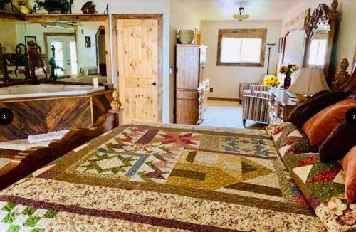 Cozy bedroom featuring a quilted bedspread, wooden furniture, and a bright window with a view.