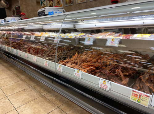 A display case filled with various types of meats and seafood in a grocery store.