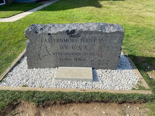 A stone monument marking the easternmost point in the U.S., located in Lubec, Maine, with a lighthouse illustration.