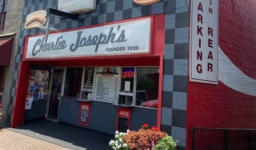 Exterior of Charlie Joseph's, a restaurant with a red and gray facade, featuring a sign and an open window.