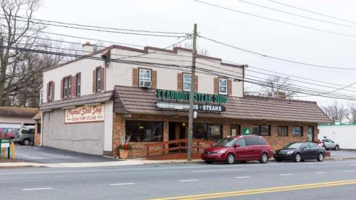 A steakhouse with a stone facade and a sloped roof, located on a busy street with power lines overhead.
