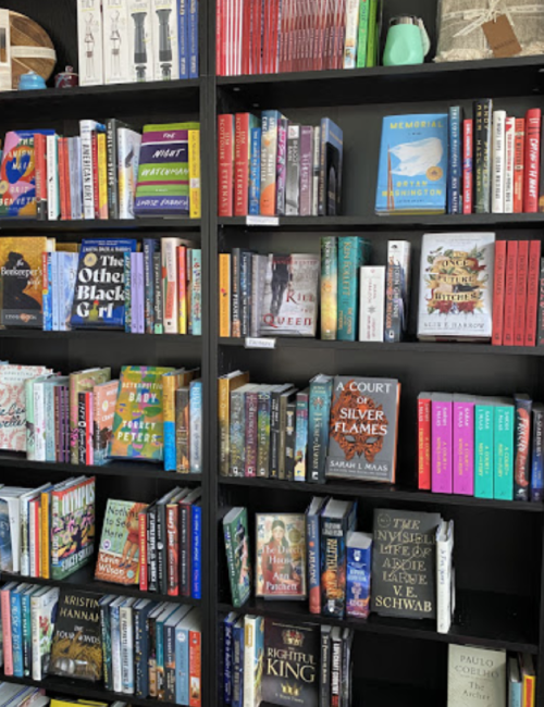 A colorful bookshelf filled with various books, showcasing a mix of genres and authors.