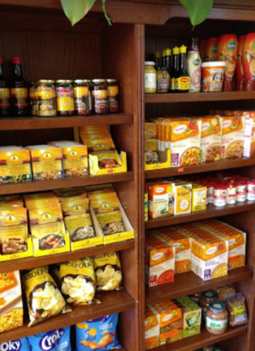 Shelves filled with various packaged food items, including sauces, snacks, and meal kits.