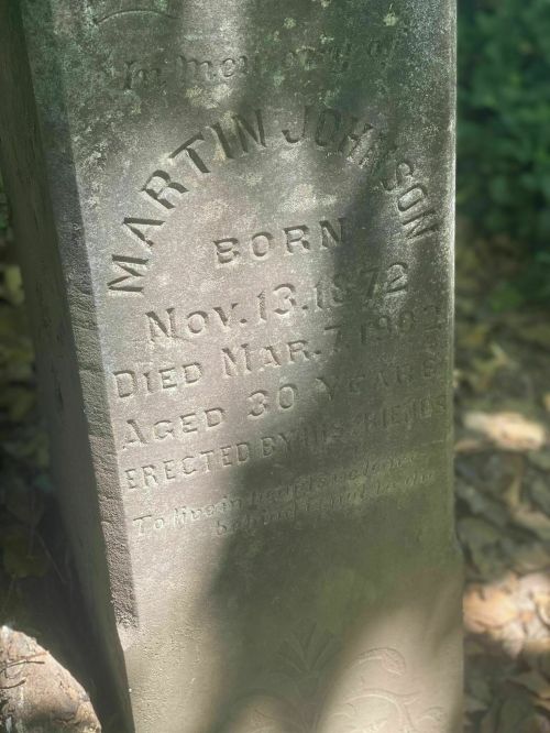 A weathered gravestone inscribed with "Martin Johnson, Born Nov. 13, 1872, Died Mar. 1, 1903, Aged 30 years."