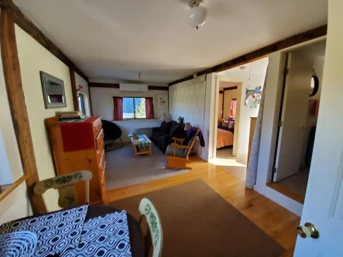 Cozy interior of a room with a dining area, living space, and a glimpse of a bedroom in a warm, inviting setting.