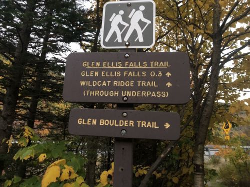 Trail sign with directions to Glen Ellis Falls, Wildcat Ridge, and Glen Boulder Trail, surrounded by autumn foliage.