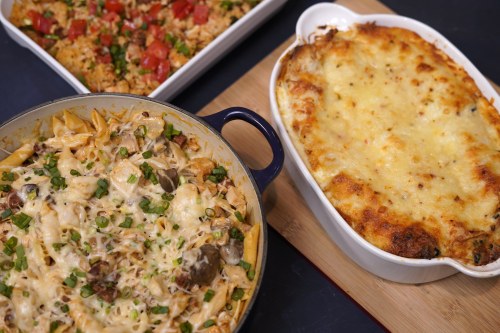A table featuring three dishes: creamy pasta bake, cheesy casserole, and a side of rice with tomatoes and herbs.