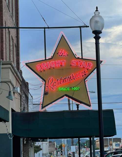 Neon sign of the Bright Star Restaurant, shaped like a star, with the year "since 1907" displayed below.