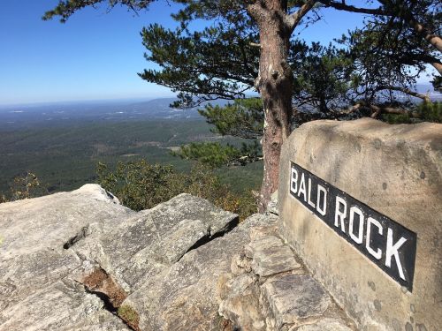 A rocky outcrop labeled "Bald Rock" overlooks a vast green landscape under a clear blue sky.