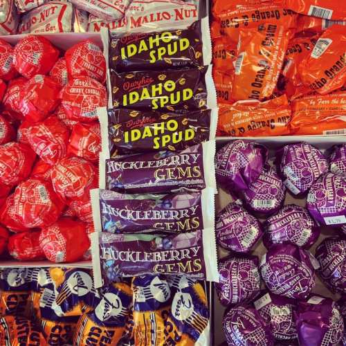 A colorful assortment of candies, including Idaho Spud, Huckleberry Gems, and various wrapped treats in vibrant packaging.