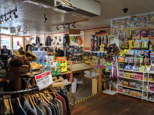 A cozy retail store filled with outdoor gear, clothing, and various colorful merchandise on display.