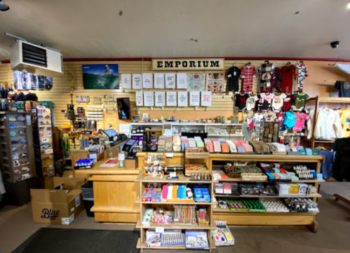 A cozy emporium interior featuring a wooden counter, shelves of merchandise, and a variety of colorful items for sale.